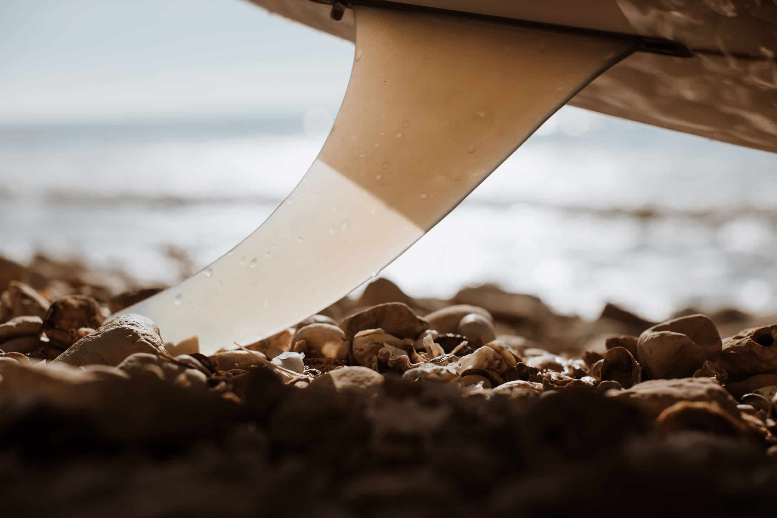 Shapers-Club- Une planche de surf est traînée sur le sable. -surfshop-surfboard